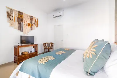 a bedroom with a bed and a tv and a table at RK3, 2 beds villa 15 min walk to Double Six Beach in Seminyak