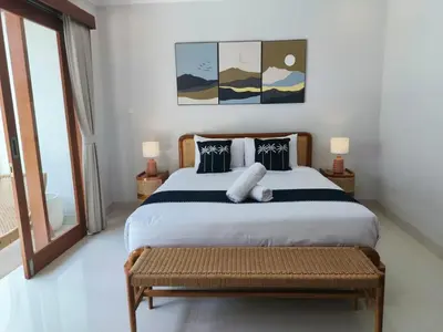 a bedroom with a large bed with a bench in it at RK4 Brand New 2Bedroom Villa Near Seminyak in Seminyak