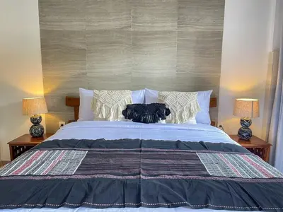 a bedroom with a large bed with two lamps at RK5, 2 beds villa 15 min walk to Double Six Beach in Seminyak