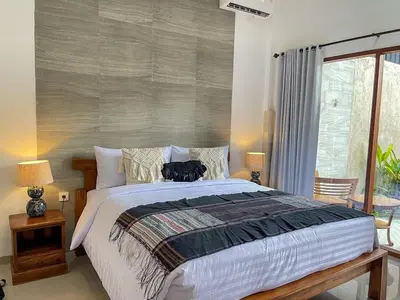 a bedroom with a large bed with two lamps at RK5, 2 beds villa 15 min walk to Double Six Beach in Seminyak