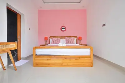 a bedroom with a wooden bed with a pink wall at Bright, Airy & Private, your 2BR Bali Escape in Seminyak