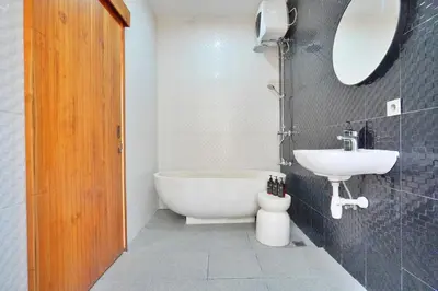 a bathroom with a white tub and a sink at Bright, Airy & Private, your 2BR Bali Escape in Seminyak