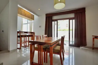 a dining room with a wooden table and chairs at NR Villa, 2 Bedroom Villa Kerobokan in Seminyak