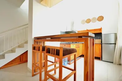 a kitchen with a bar with two stools at NR Villa, 2 Bedroom Villa Kerobokan in Seminyak