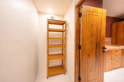 a bathroom with a wooden door and a sink at Gate 11 Mezzanine one in Denpasar