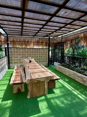 a wooden table and bench in a pavilion at Villa Vela 2 BR - Vela 3 with Private Pool & Rooftop in Seminyak