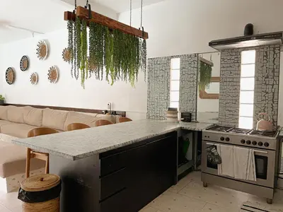 a kitchen with a counter and a stove and a couch at Villa Vela 2 BR - Vela 3 with Private Pool & Rooftop in Seminyak