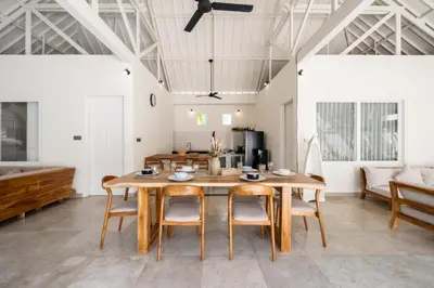 a dining room with a wooden table and chairs at Uma dharma villas 2 in Seminyak