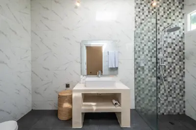 a white bathroom with a sink and a shower at Uma dharma villas 2 in Seminyak