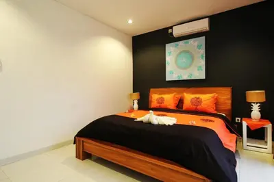 a bedroom with a bed with an animal laying on it at Villa Dreamz - six bedrooms private villa in Legian