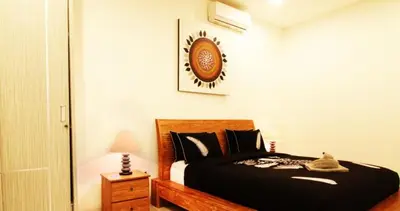 a bedroom with a bed with a cat laying on it at Villa Dreamz - six bedrooms private villa in Legian