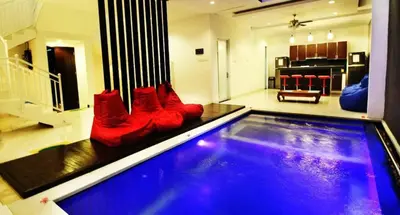 a swimming pool with red boots sitting on top of it at Villa Dreamz - six bedrooms private villa in Legian