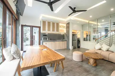 a kitchen and living room with a wooden table at Splendid Villa 3Br Center Seminyak in Seminyak