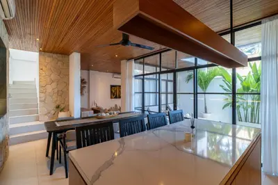an open kitchen with a dining table and chairs at Modern 3BR Villa Seminyak, central location in Seminyak