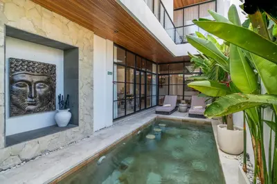 a pool in the middle of a house with a building at Modern 3BR Villa Seminyak, central location in Seminyak