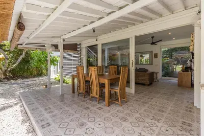 a patio with a wooden table and chairs at Villa Sarah 4 chambres près de la plage Oberoi Seminyak in Seminyak