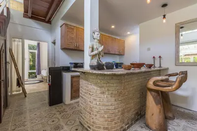 a kitchen with a brick counter with a statue at Villa Sarah 4 chambres près de la plage Oberoi Seminyak in Seminyak