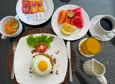 a plate of food with an egg on a table at Arjuna Villa 3 Bedroom Villa Seminyak in Seminyak