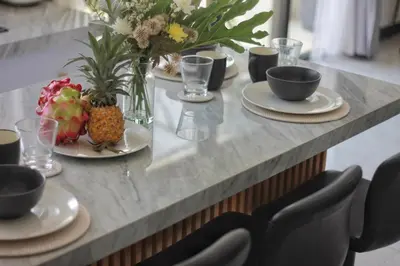 a table with plates of food and flowers on it at Villa Lisa - 3BR with pool Near Bali Mall Galleria in Kuta