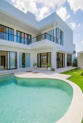 a house with a swimming pool in front of it at Sunset room in a shared 4 bedroom villa in Canggu