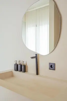 a mirror on a wall above a bathroom sink at Sunset room in a shared 4 bedroom villa in Canggu