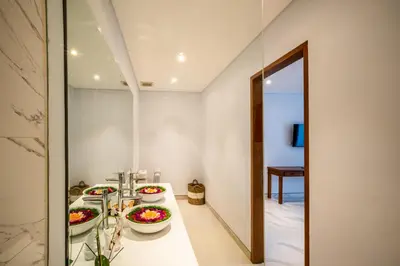 a bathroom with three sinks and a mirror at Villa Lavender Seminyak in Seminyak