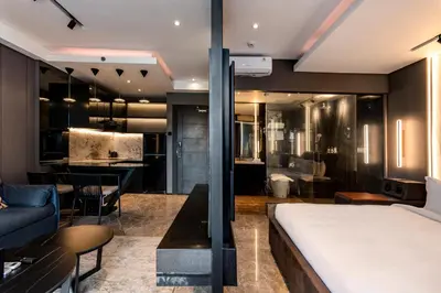 a bedroom with a bed and a living room at The Umalas Signature in Canggu