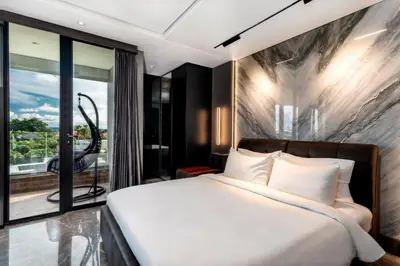a bedroom with a large bed and a balcony at The Umalas Signature in Canggu