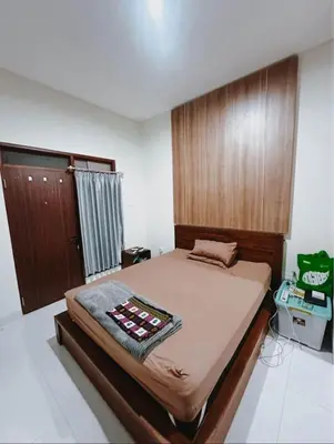 a bedroom with a large bed with a wooden headboard at Room Close to Seminyak - Cozy & Strategic Stay in Seminyak