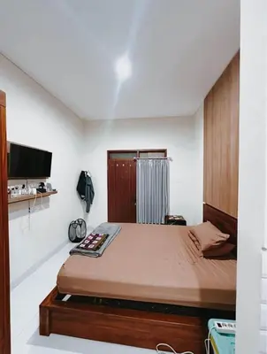 a bedroom with a bed and a flat screen tv at Room Close to Seminyak - Cozy & Strategic Stay in Seminyak