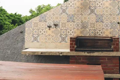 a building with a tile wall with a fireplace at The Valley Loft in Ngurah Rai International Airport