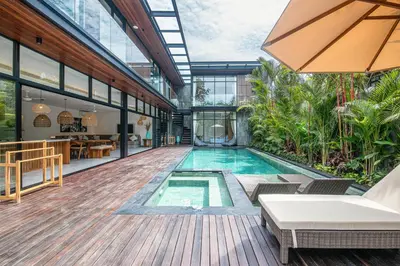 an indoor swimming pool in a building with a house at Exquisite 6-Bedroom Retreat, Jacuzzi, AC in Canggu