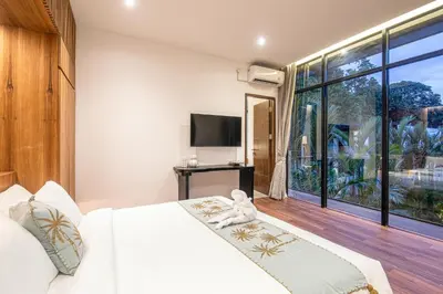 a bedroom with a bed with a teddy bear sitting on it at Exquisite 6-Bedroom Retreat, Jacuzzi, AC in Canggu