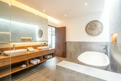 a bathroom with two sinks and a tub and a mirror at Exquisite 6-Bedroom Retreat, Jacuzzi, AC in Canggu