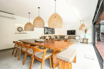 a dining room with a wooden table and chairs at Exquisite 6-Bedroom Retreat, Jacuzzi, AC in Canggu
