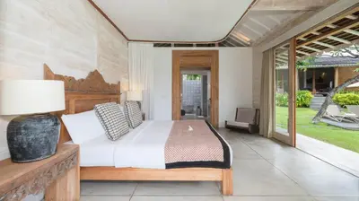 a bedroom with a bed and a large window at Alea Estate by Villa Finder in Kerobokan
