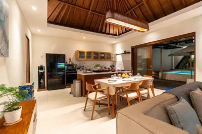 a living room and kitchen with a table and a couch at Luxury 4BR Private Pool Villa, Serene Lux Jimbaran in Jimbaran