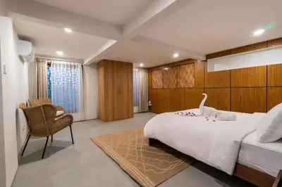 a bedroom with a large white bed and a chair at Luxury 4BR Private Pool Villa, Serene Lux Jimbaran in Jimbaran