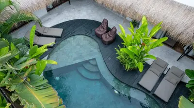 an overhead view of a swimming pool with chairs and plants at Villa Mimpikita - Stunning Ibiza-Inspired Villa Near Umalas with Private Pool in Kerobokan