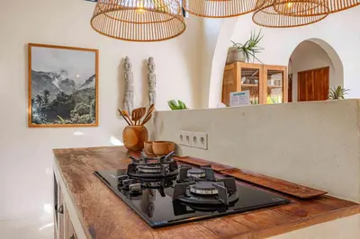 a stove top oven in a kitchen with chandeliers at Villa Mimpikita - Stunning Ibiza-Inspired Villa Near Umalas with Private Pool in Kerobokan