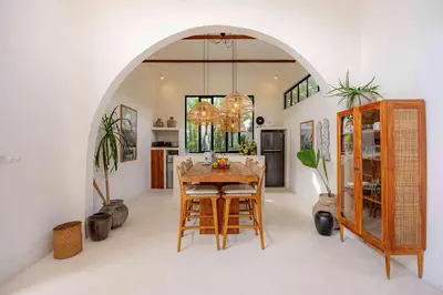 a dining room with a table and some plants at Villa Mimpikita - Stunning Ibiza-Inspired Villa Near Umalas with Private Pool in Kerobokan