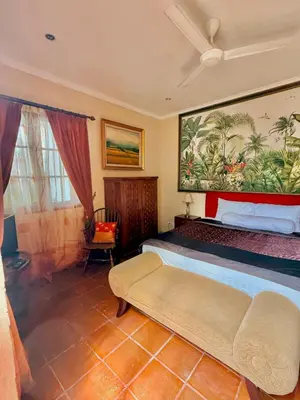 a bedroom with a bed and a painting on the wall at Casa Sophia by Kayana in Sanur