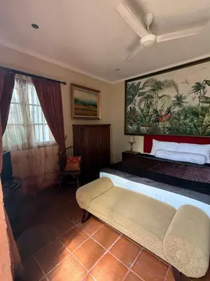 a bedroom with a bed and a painting on the wall at Casa Sophia by Kayana in Sanur