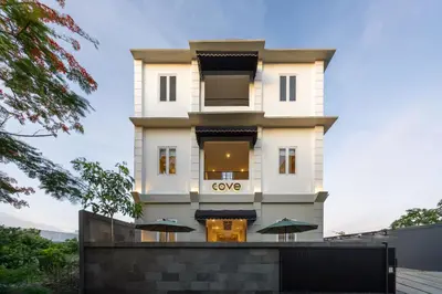 a tall white building with a sign on it at Cove Nuansa Home in Jimbaran