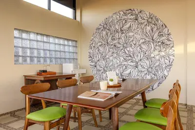 a dining room with a table and green chairs at Cove Nuansa Home in Jimbaran