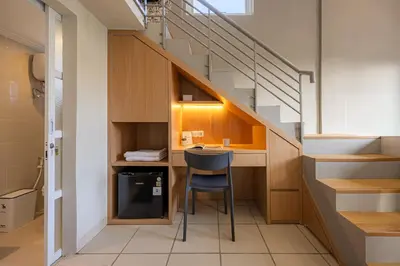 a small kitchen with a desk under a staircase at Cove Nuansa Home in Jimbaran