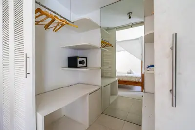 a kitchen with white cabinets and a microwave at The Oasis Villa in Kerobokan