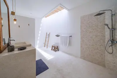 a white bathroom with a shower and a sink at The Oasis Villa in Kerobokan
