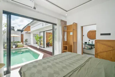 a bedroom with a bed and a swimming pool at Rosso Verde 2BR Villa near Seminyak in Seminyak