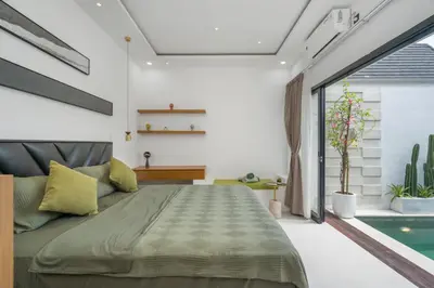 a bedroom with a large bed and a swimming pool at Rosso Verde 2BR Villa near Seminyak in Seminyak